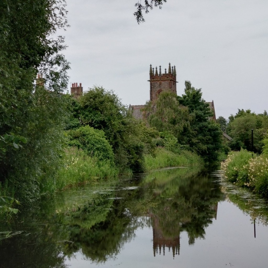Polwarth Parish Church, aka the Kirk on the Canal, which has hosted all-day singings in Edinburgh. The church tower is visible among trees and reflected in the Union Canal.