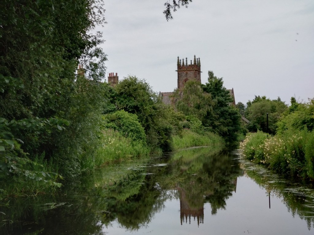 Polwarth Parish Church, aka the Kirk on the Canal, which has hosted all-day singings in Edinburgh. The church tower is visible among trees and reflected in the Union Canal.